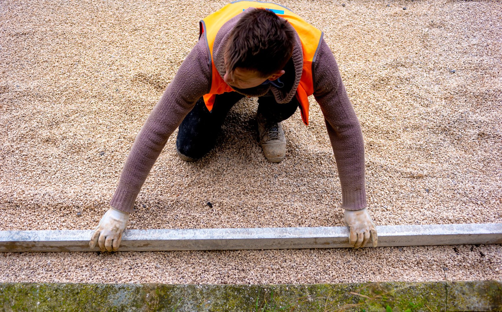 Construction worker laying interlocking paving concrete