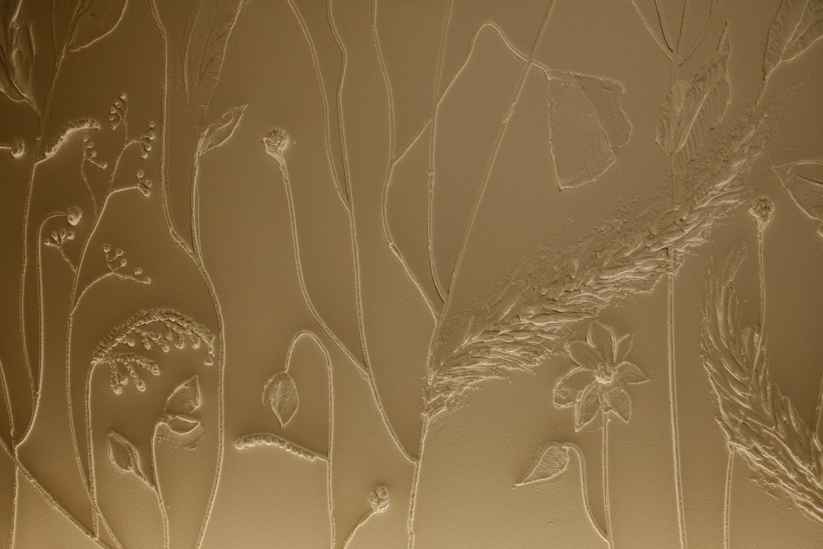 Beige flora sculpted on wall, textured art.