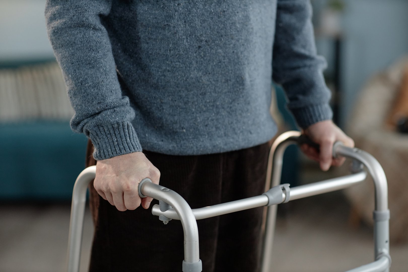 Cropped shot of senior man walking slowly while holding frame for support using comfortable handle grips while moving around domestic environment, copy space