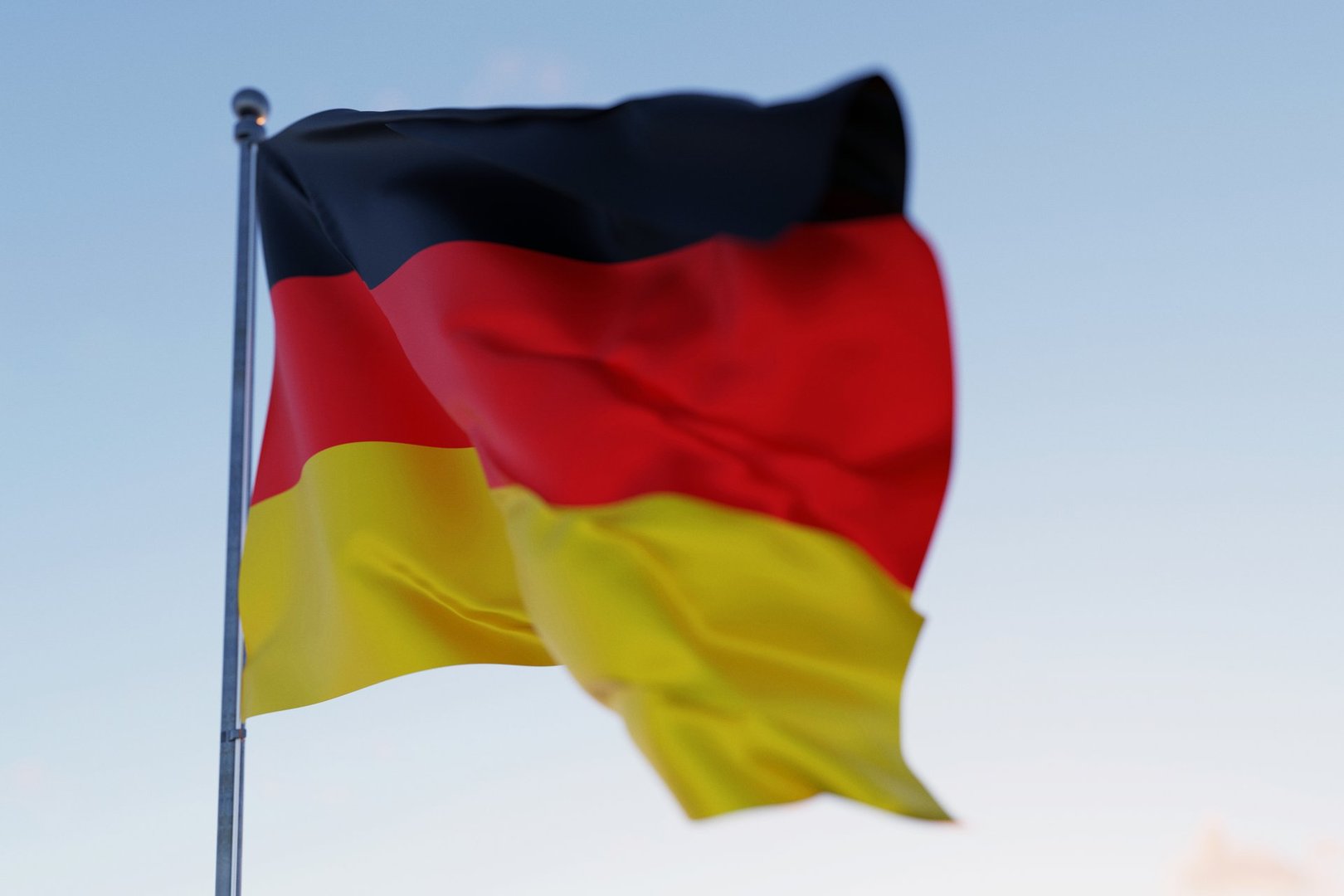 German national flag waving in the wind against a clear blue sky, symbolizing patriotism, unity, heritage, and national identity.