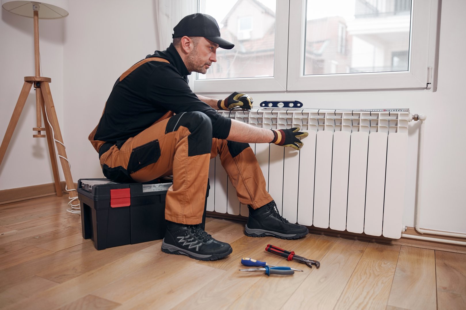 Central heating mechanic and handyman fixing home radiator, gas crisis and seasonal issues.