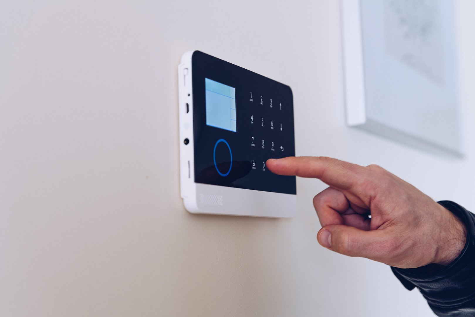 Close up picture on the man's hand unlocking the alarm in the apartment. Home security alarm.