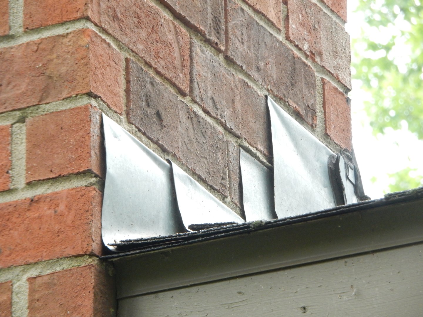 Metal flashing on the side of a brick chimney