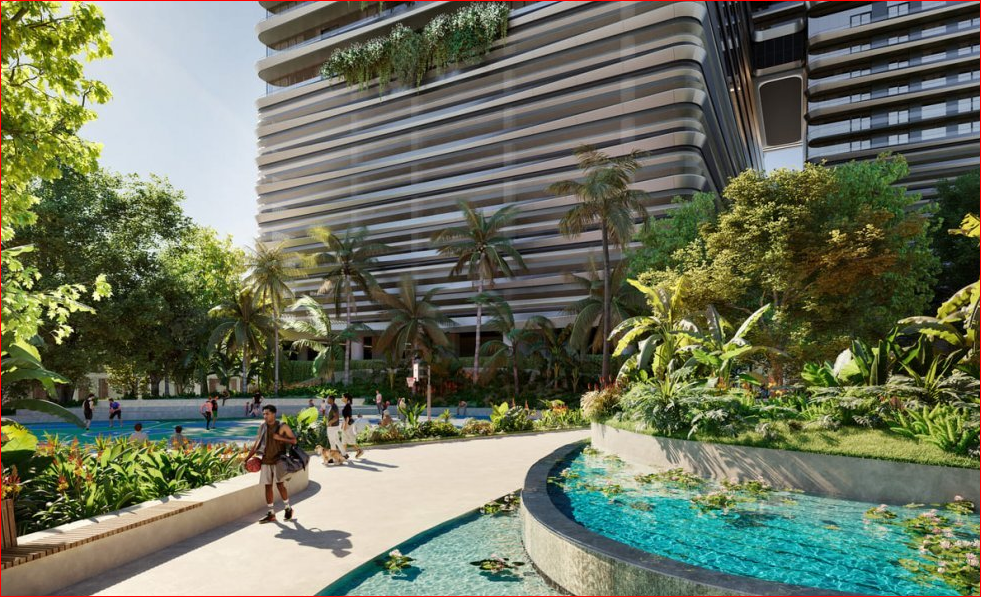 Lush garden courtyard with water feature, tropical plants, and a modern multi-story building in the background.
