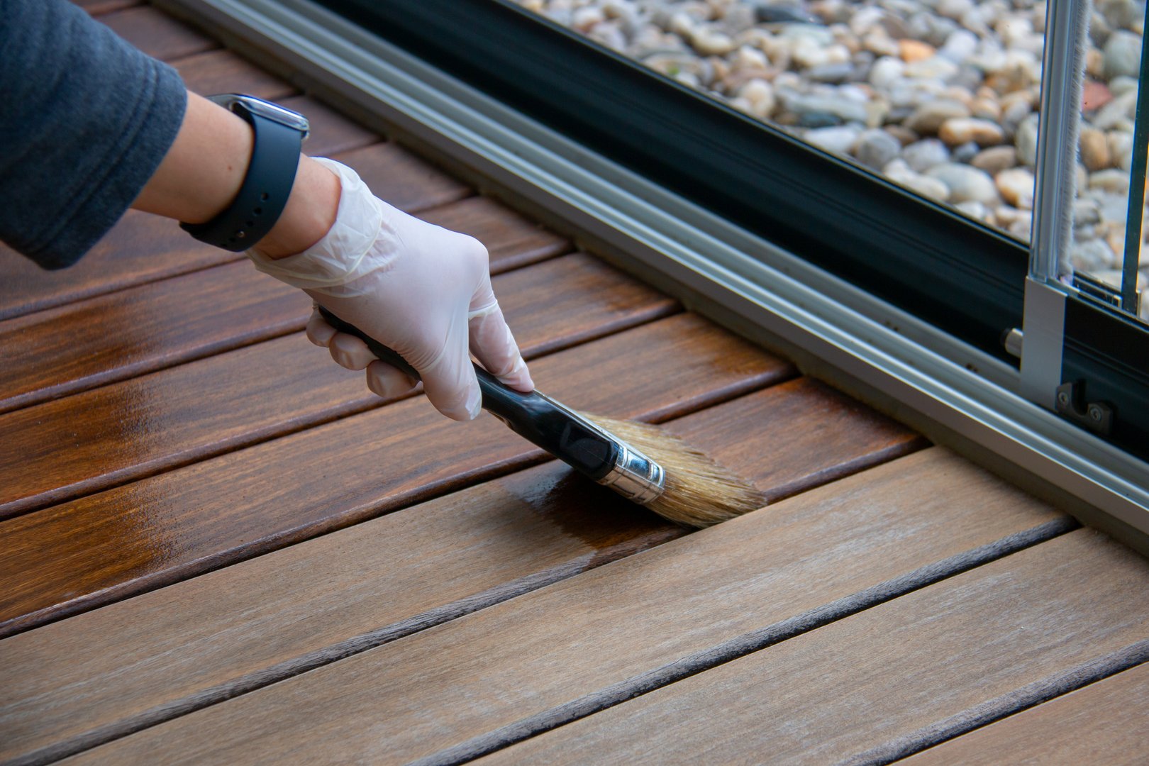 Worker applying deck stain