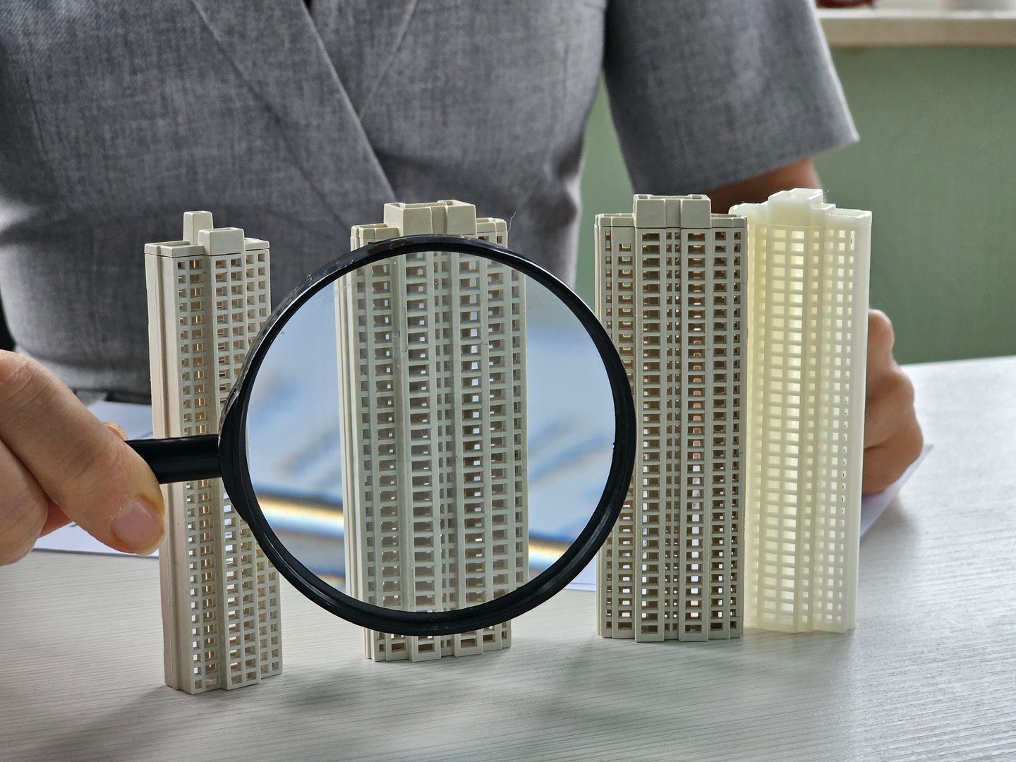 Search for a real estate agency, property insurance, mortgage or new home. Woman with magnifying glass and real estate at home