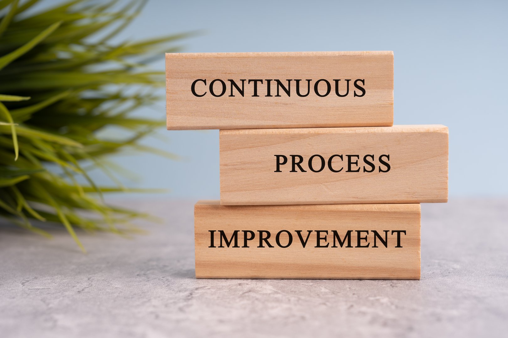 Continuous process improvement text on white wooden blocks