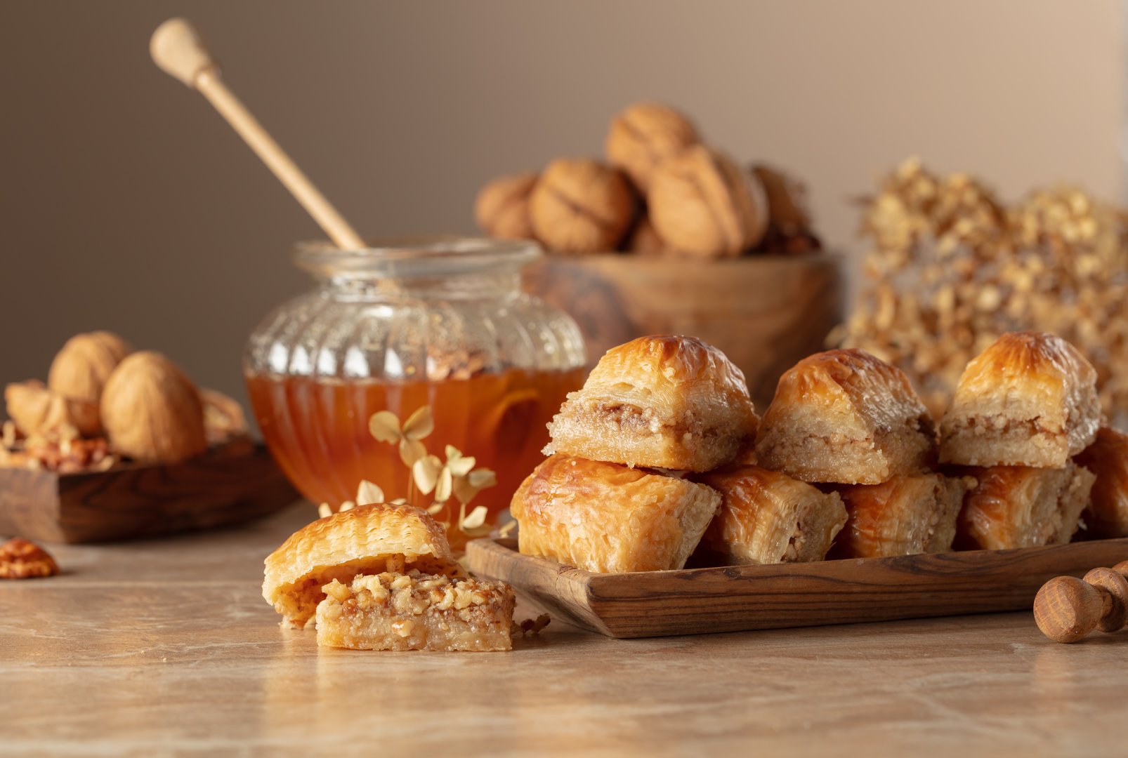 Baklava with walnuts and honey on a beige background. Traditional East desert in wooden dish. Copy space.