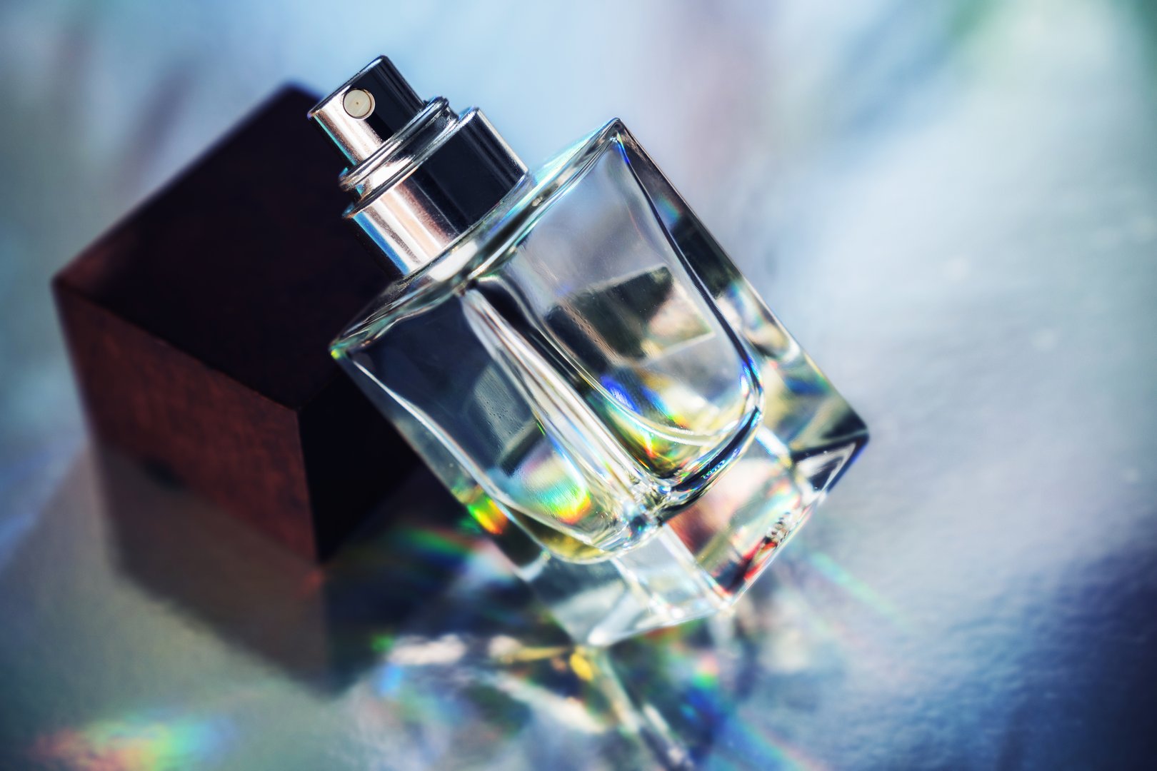 Close-Up of Glass Perfume Bottle with Rainbow Reflections.