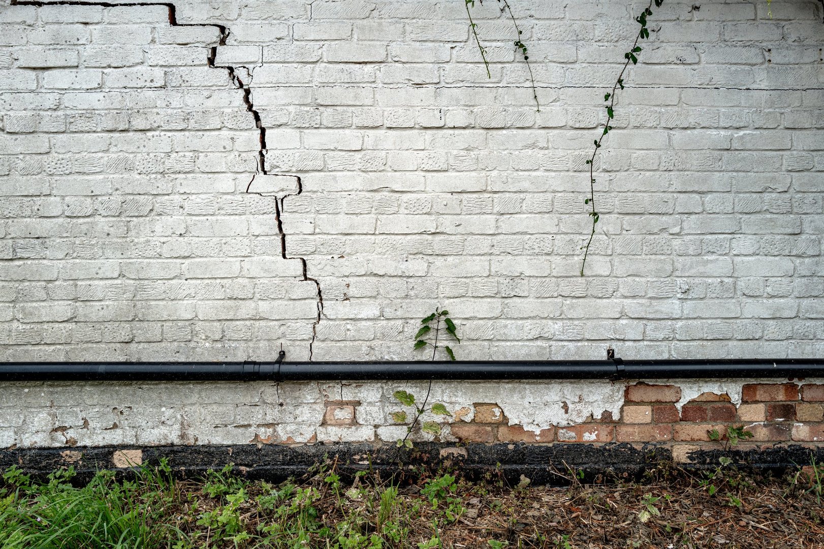 Bad building subsidence seen on an old English cottage. The bricks themselves appear to be broken and requires extensive restoration.