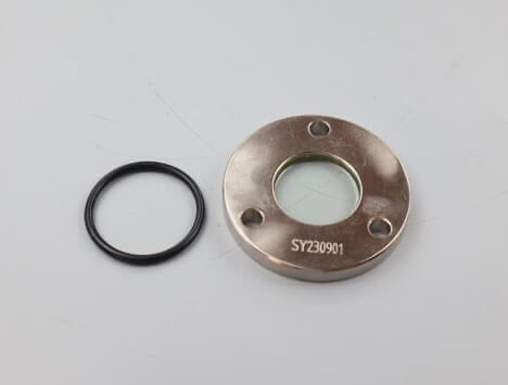 Metal flange with a glass center and O-ring, labeled SY230901, placed on a plain surface.