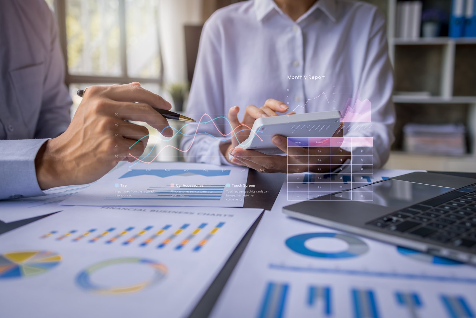 Team businesspeople or an accountant team are analyzing data charts, graphs, and a dashboard on a laptop screen in order to prepare a statistical report and discuss financial data in an office.