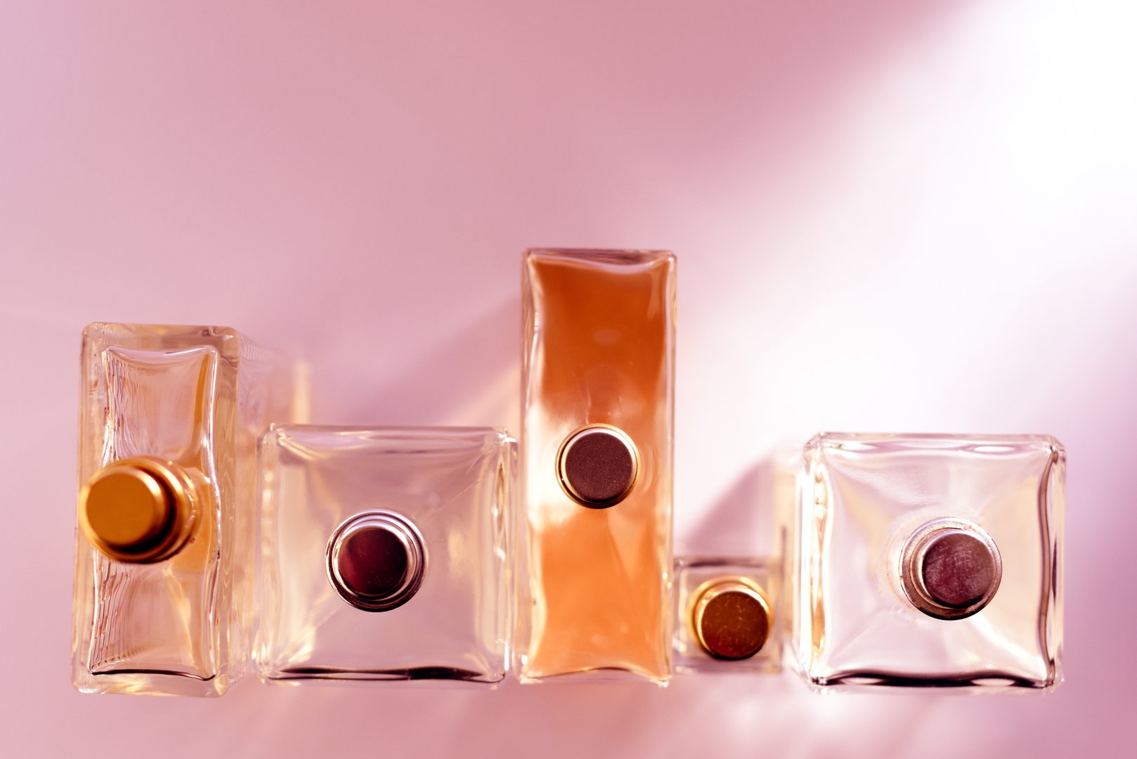 Perfume bottles of ladies perfumes from overhead angle toned with pink colour