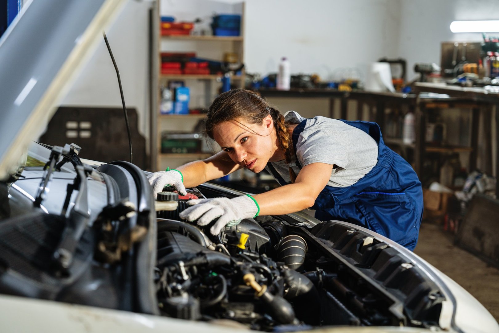 Young female mechanic working in auto repair garage