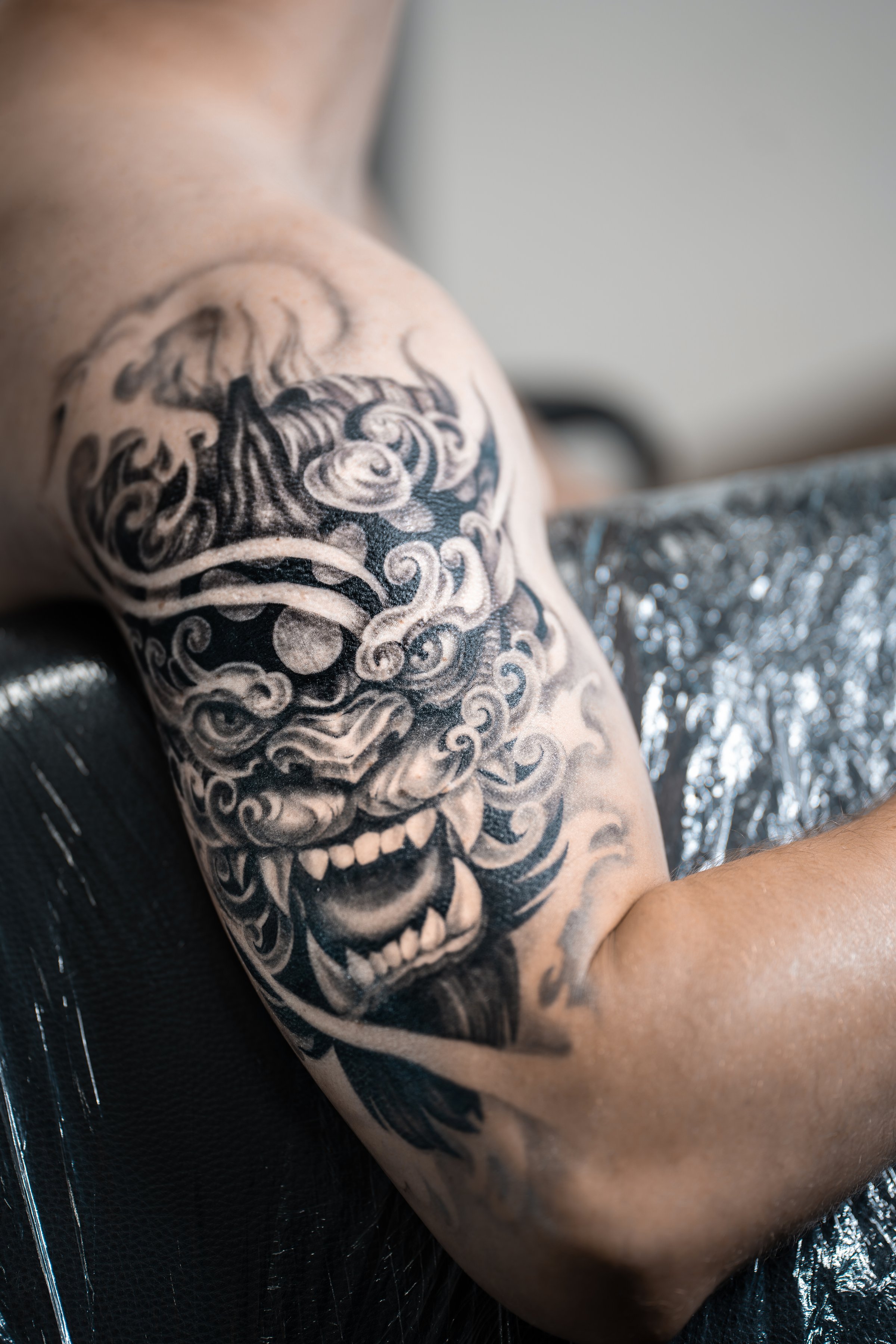 stylish black tattoo of Japanese demon mask on man hand, body art. High quality photo