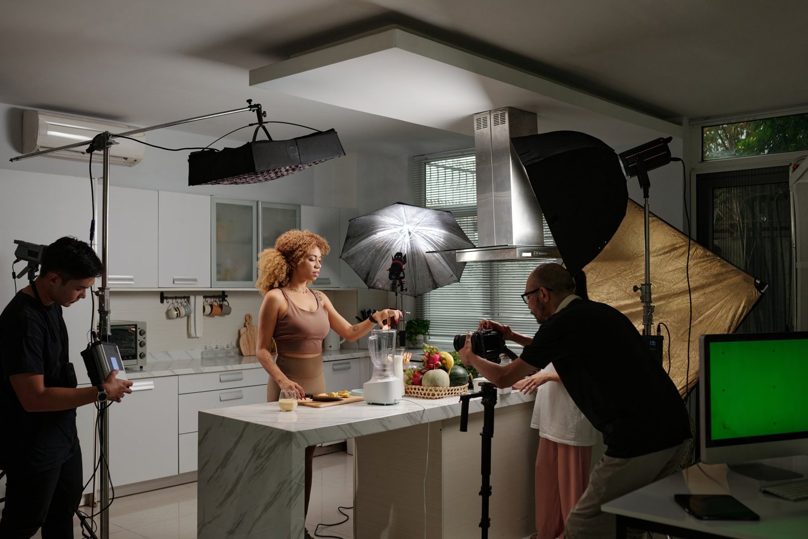 Team of operators shooting model in domestic kitchen