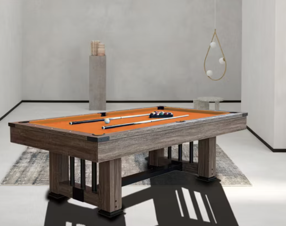 Modern pool table with orange felt and cue sticks in a minimalist room with abstract lighting and neutral decor.
