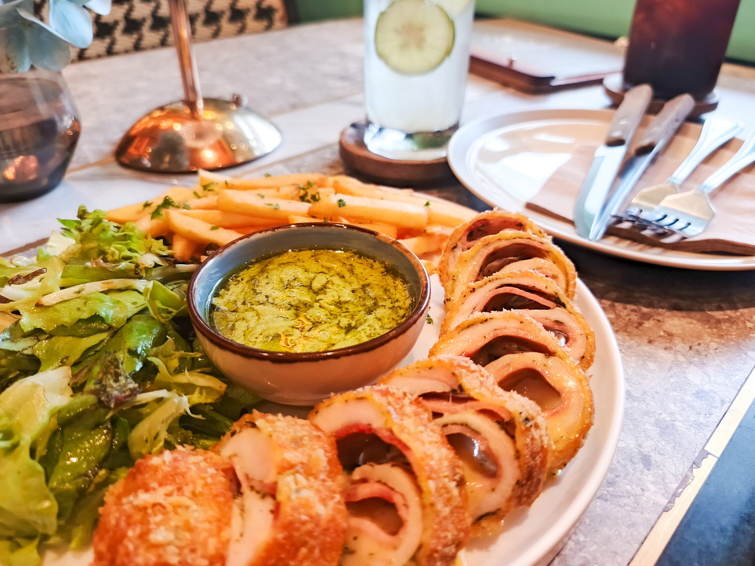 Crispy chicken cordon bleu, fresh salad, fries and dip. Delicious restaurant food, perfect for dining out.