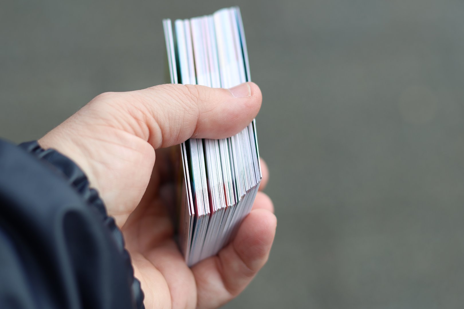 A hand holding a pack of trading soccer cards