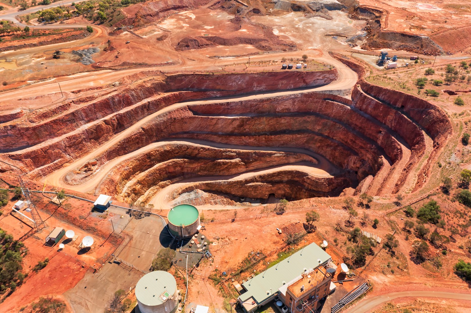 Layered deep open pit copper mine in Cobar town of Australia - aerial top down view.