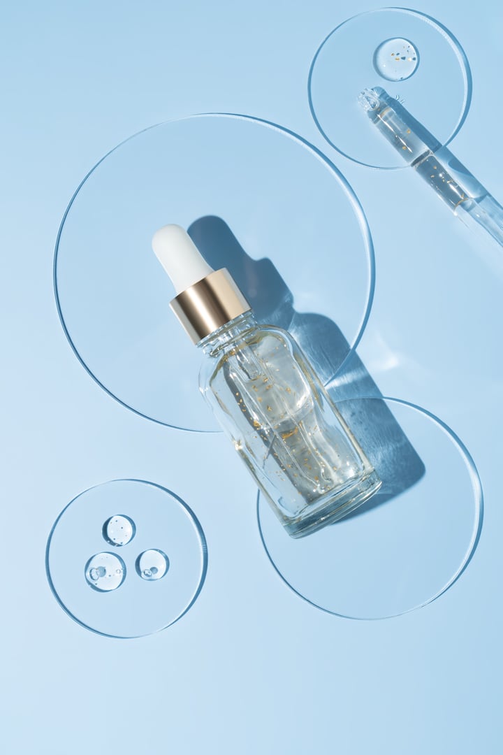 Skin care lab research. cosmetics productions, 24k gold flakes components extraction. Skin care cosmetology testing. Petri dish with dropper bottle on blue background