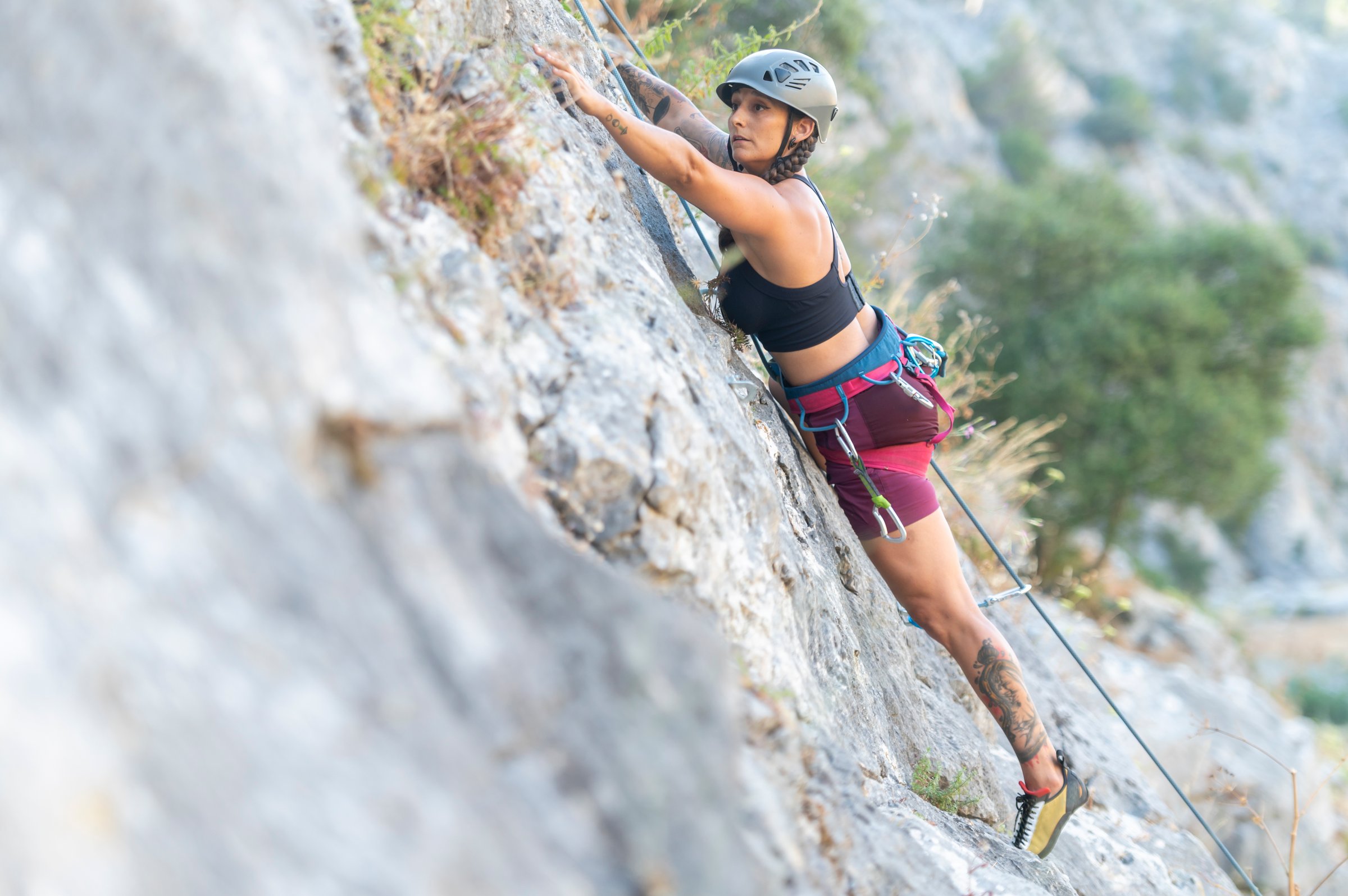 Woman skillfully climbing a rocky mountain with focus and determination - sugarfree.space nutrition guide for California athletes 40+