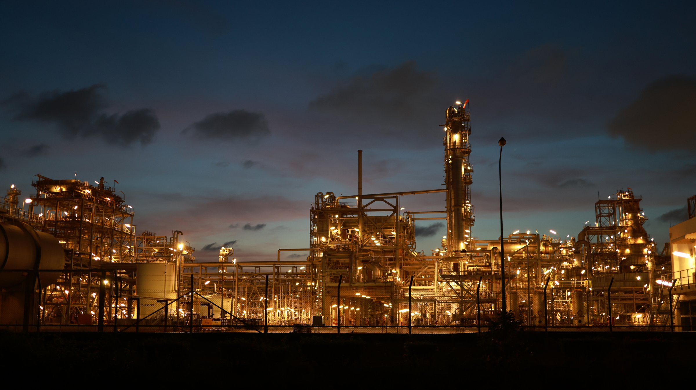 Selective focus light bokeh of a refinery plant at night. The scene depicts an industrial and factory setting.