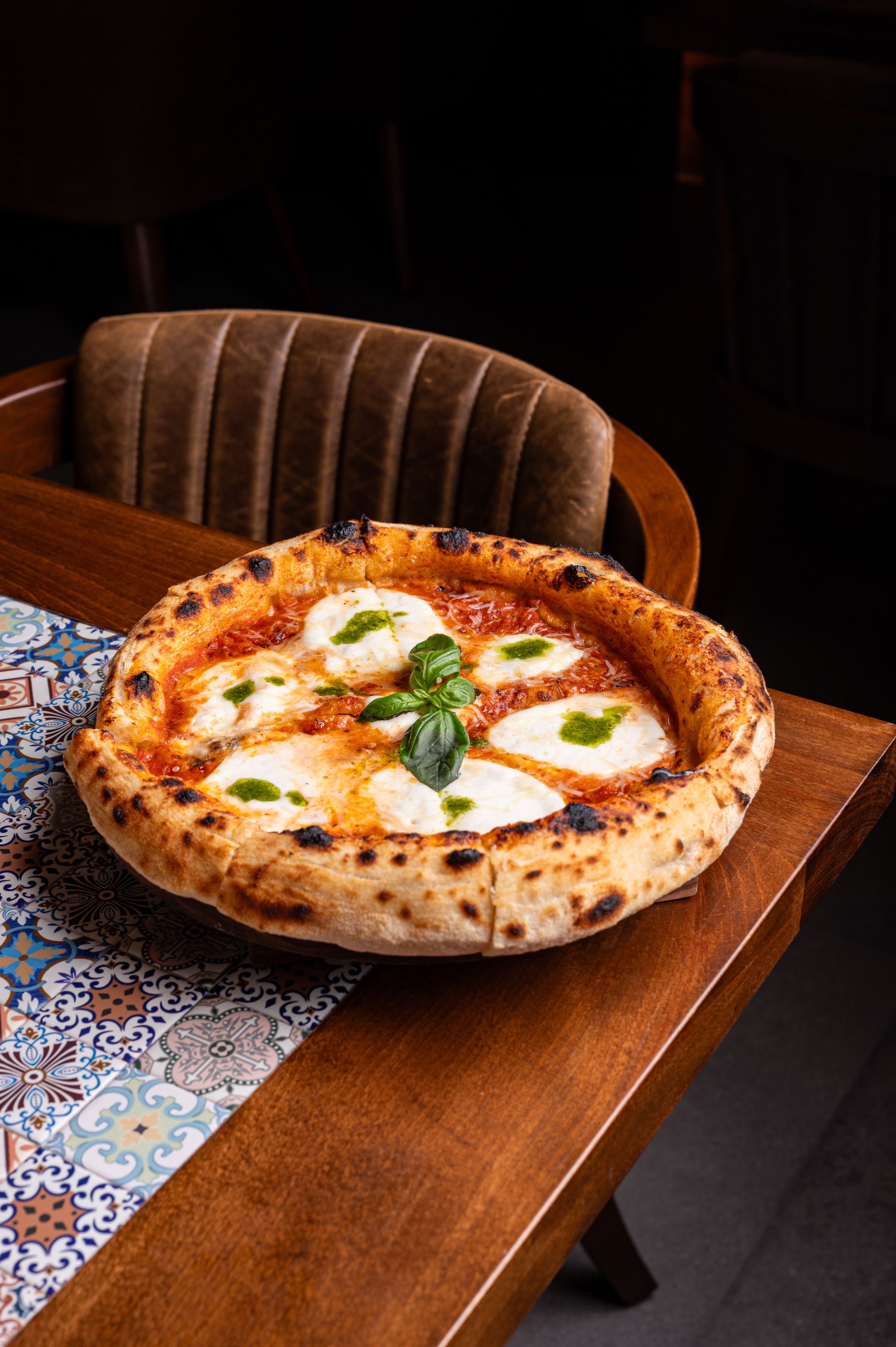 A delicious Margherita pizza with fresh basil on a wooden table, showcasing vibrant colors and textures.