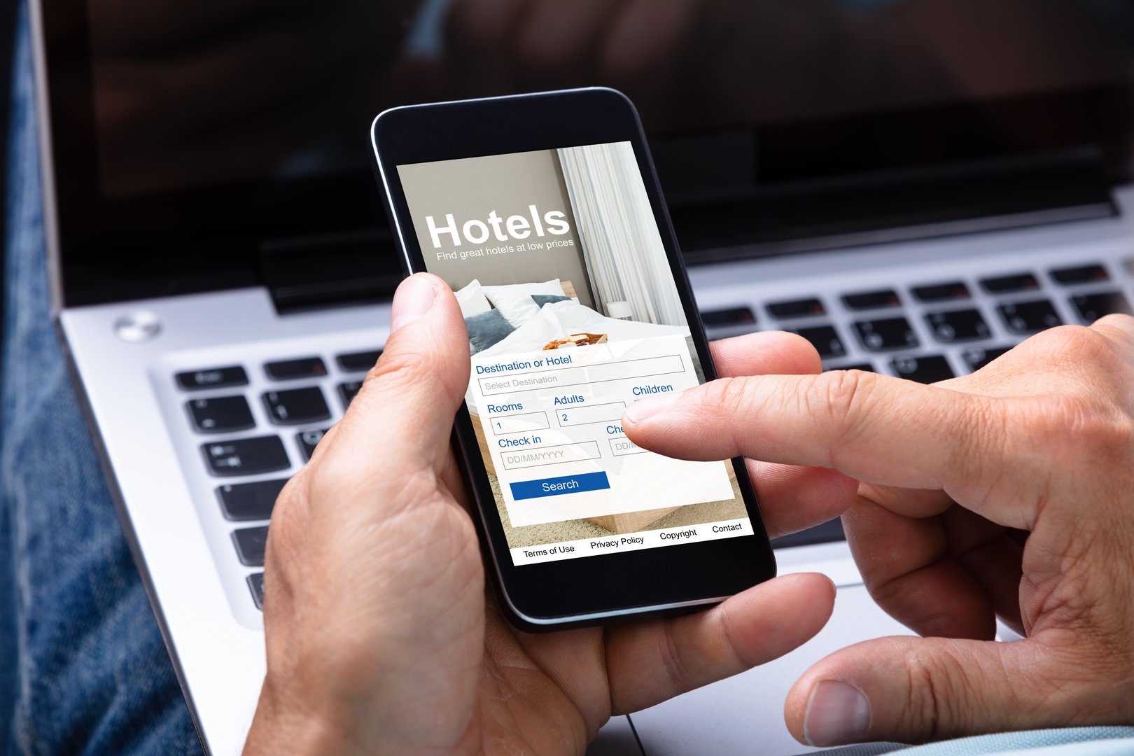 Close-up Of A Man's Hand Booking Hotel Using Smartphone