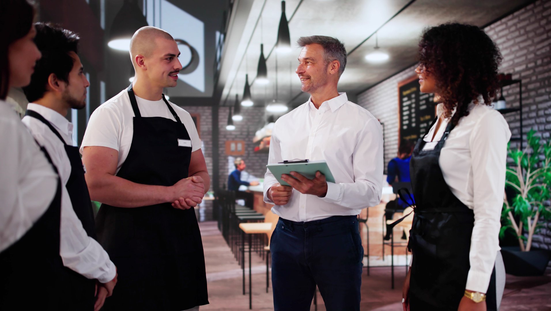 Store Manager In Coffee Shop Meeting With Team. Management Planning