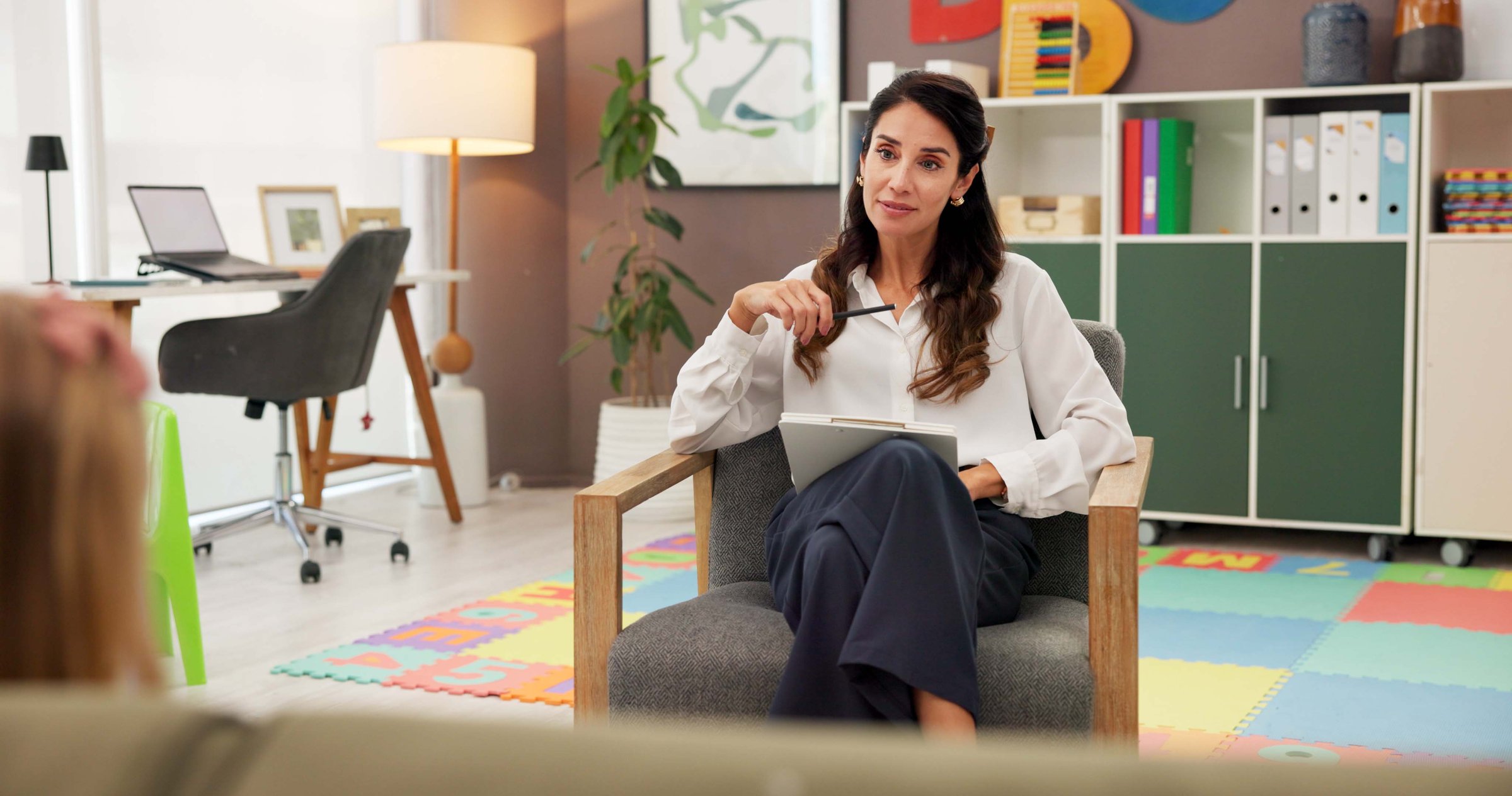 Psychology, woman and clipboard with child, talk and happy with notes for emotional assessment at clinic. Person, therapist and kid with checklist, question and listen with test for mental health