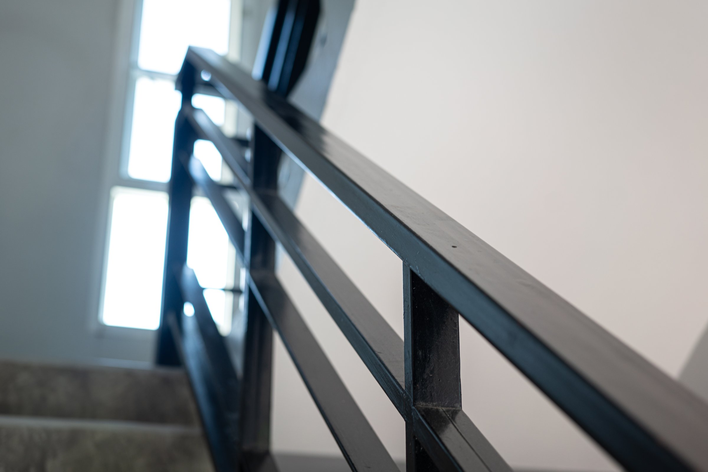 Close-up at stairway iron handrail banister of the high rise building place. Building equipment object part, selective focus.
