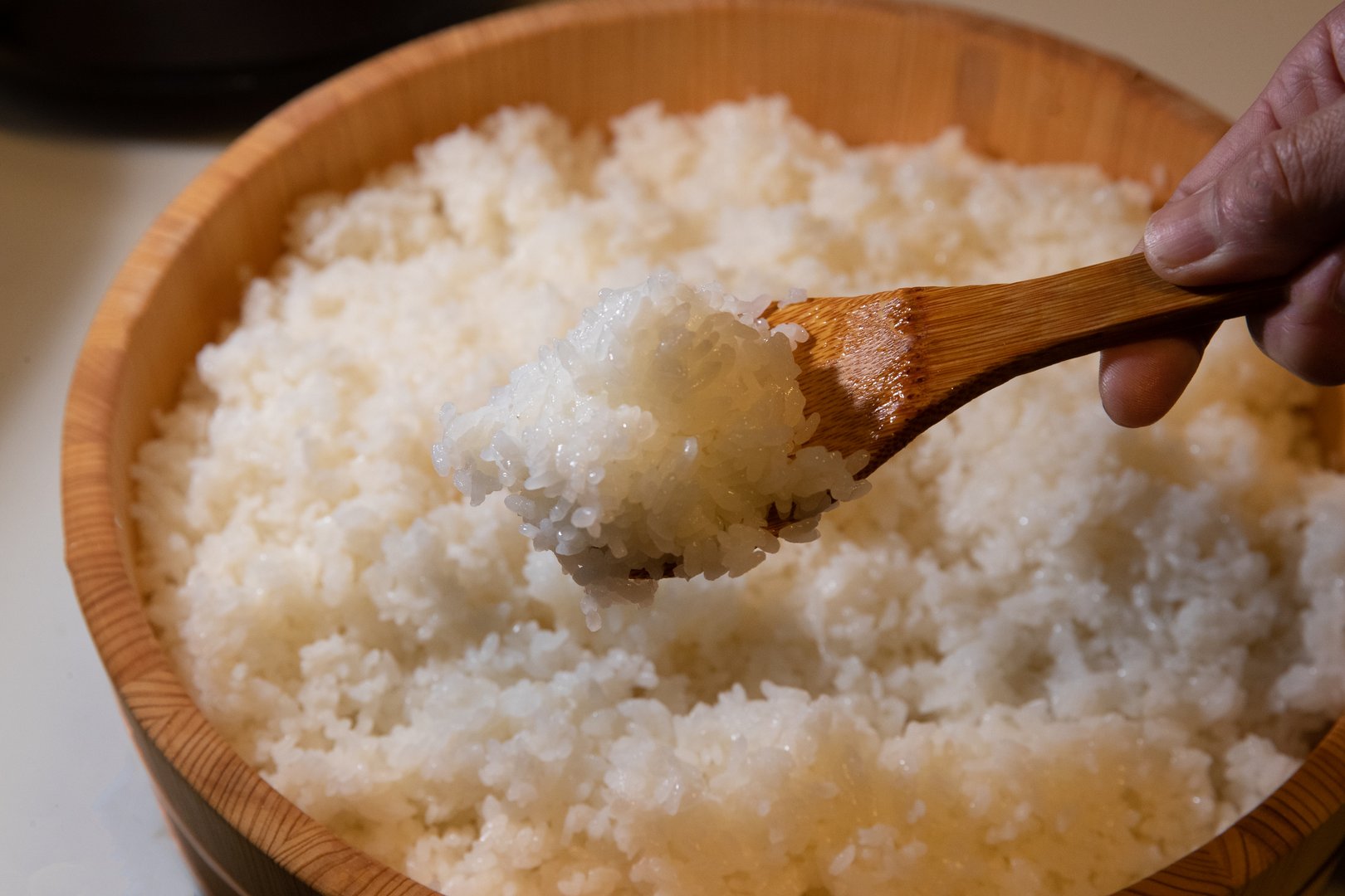 This photo features freshly prepared sushi rice placed in a traditional wooden hangiri. The wooden tub helps absorb excess moisture, ensuring the perfect texture for sushi preparation. The simplicity of the image highlights the essence of traditional Japanese cuisine.