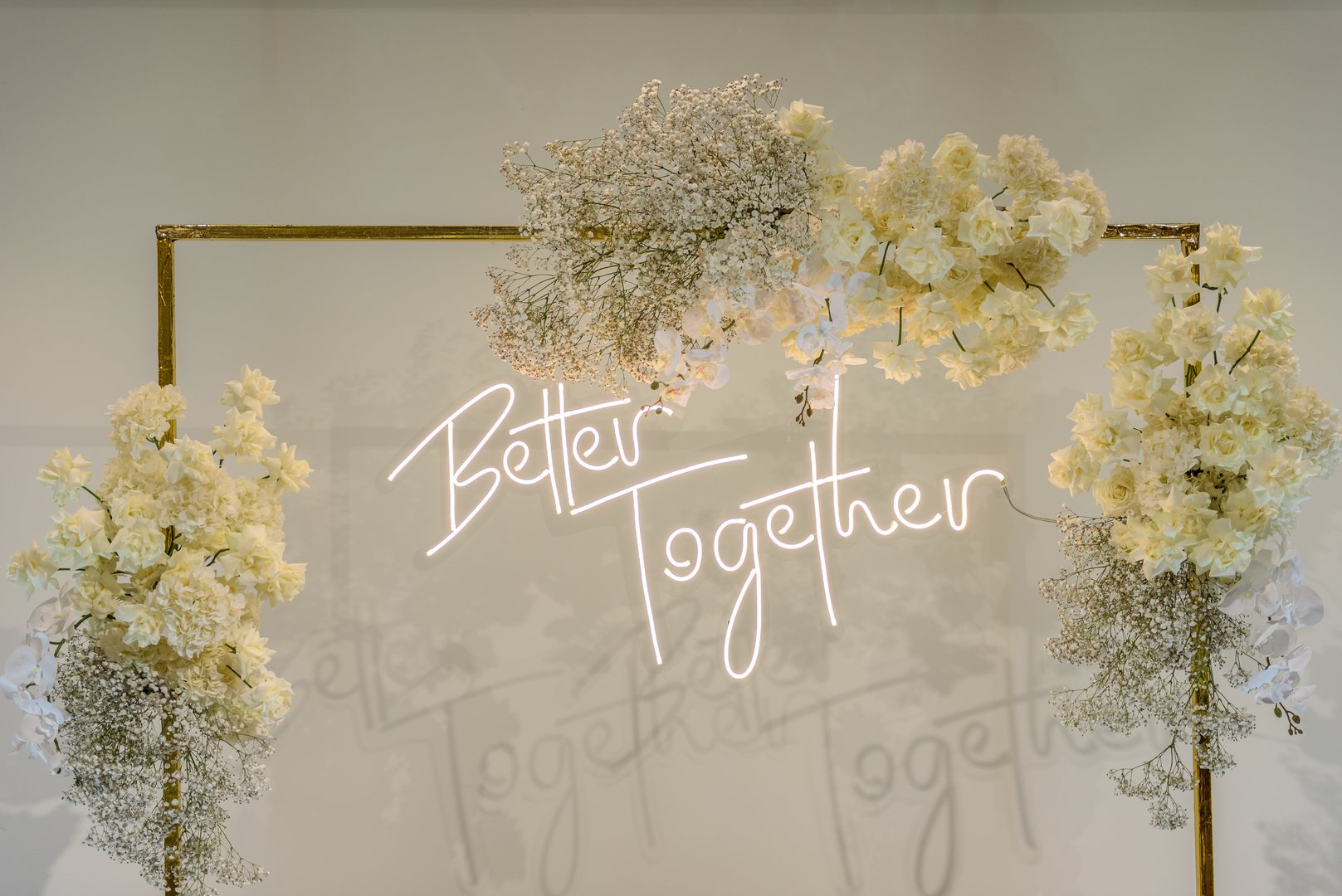 Better together text on photo-wall. Arch decorated flowers, greenery. Wedding reception. Celebration concept. Decorations in luxury ceremony in hall restaurant. Trendy decor for party in banquet area.