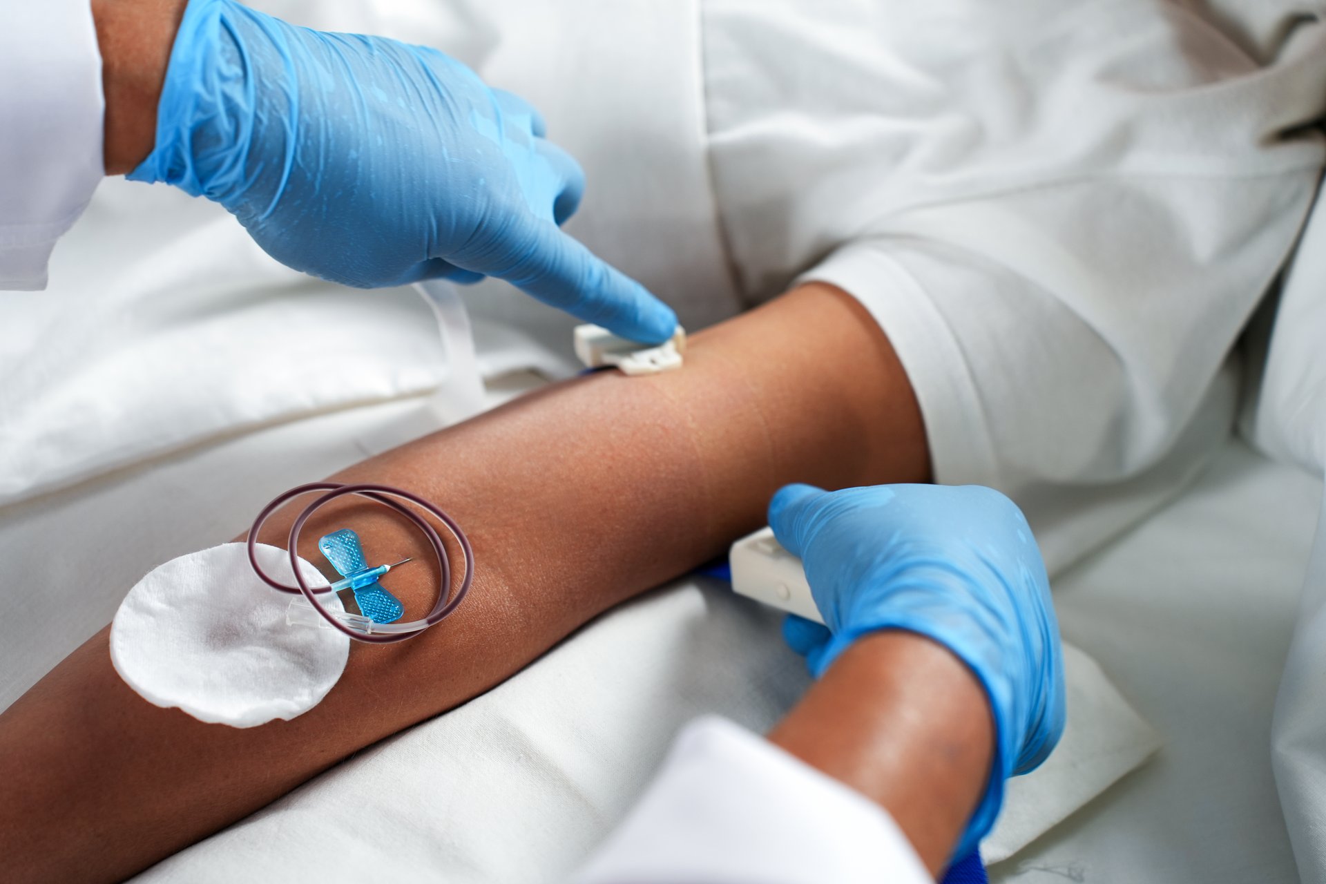 A health worker removes a bandage after drawing blood