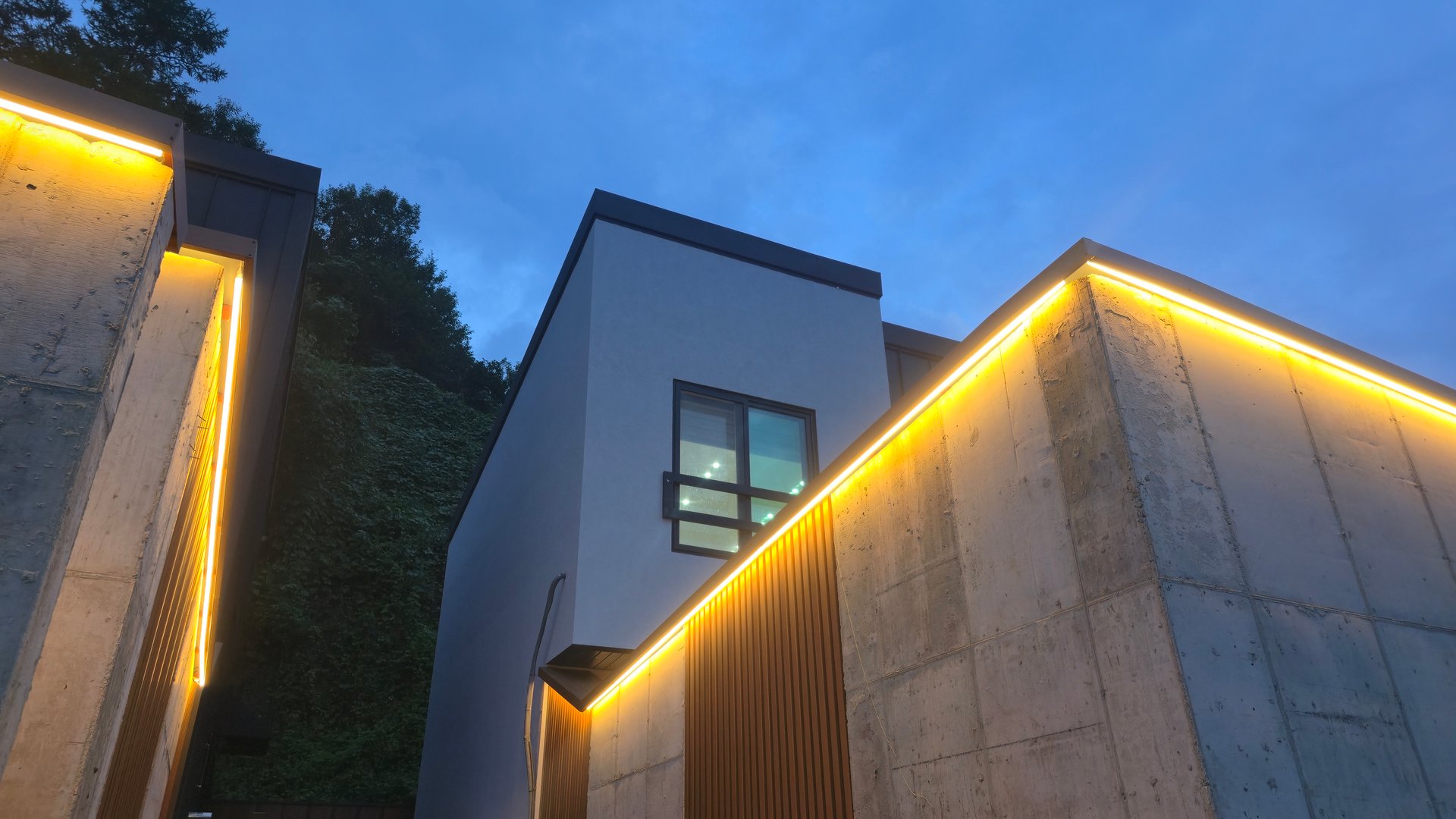 Contemporary architecture featuring clean lines, soft lighting, and a sophisticated urban aesthetic surrounded by nature.