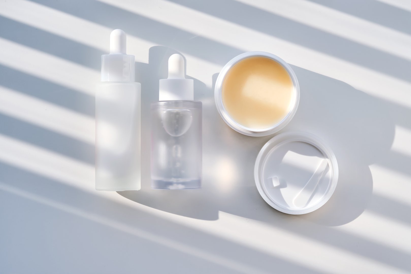 A set of care cosmetics on a white background with stripes of shadows. High quality photo.