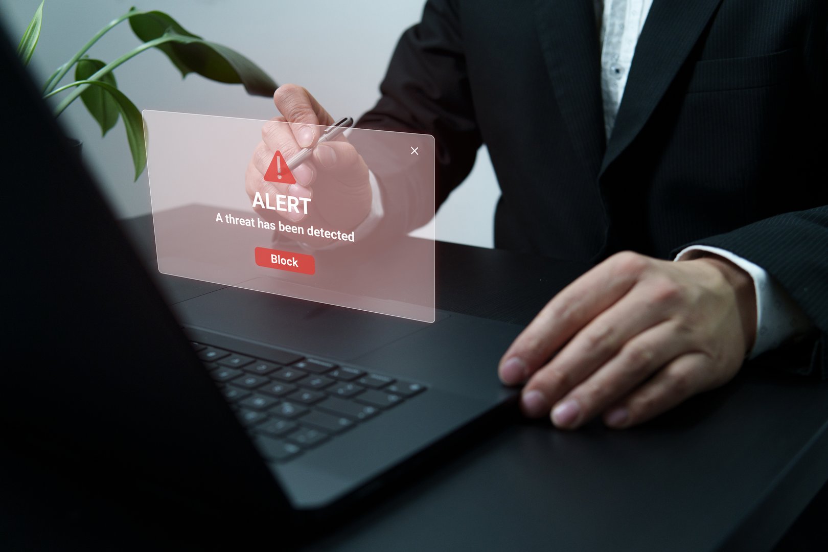 a person using the laptop, a message of a detected threat is observed. Concept of cybersecurity, computer attacks, hackers