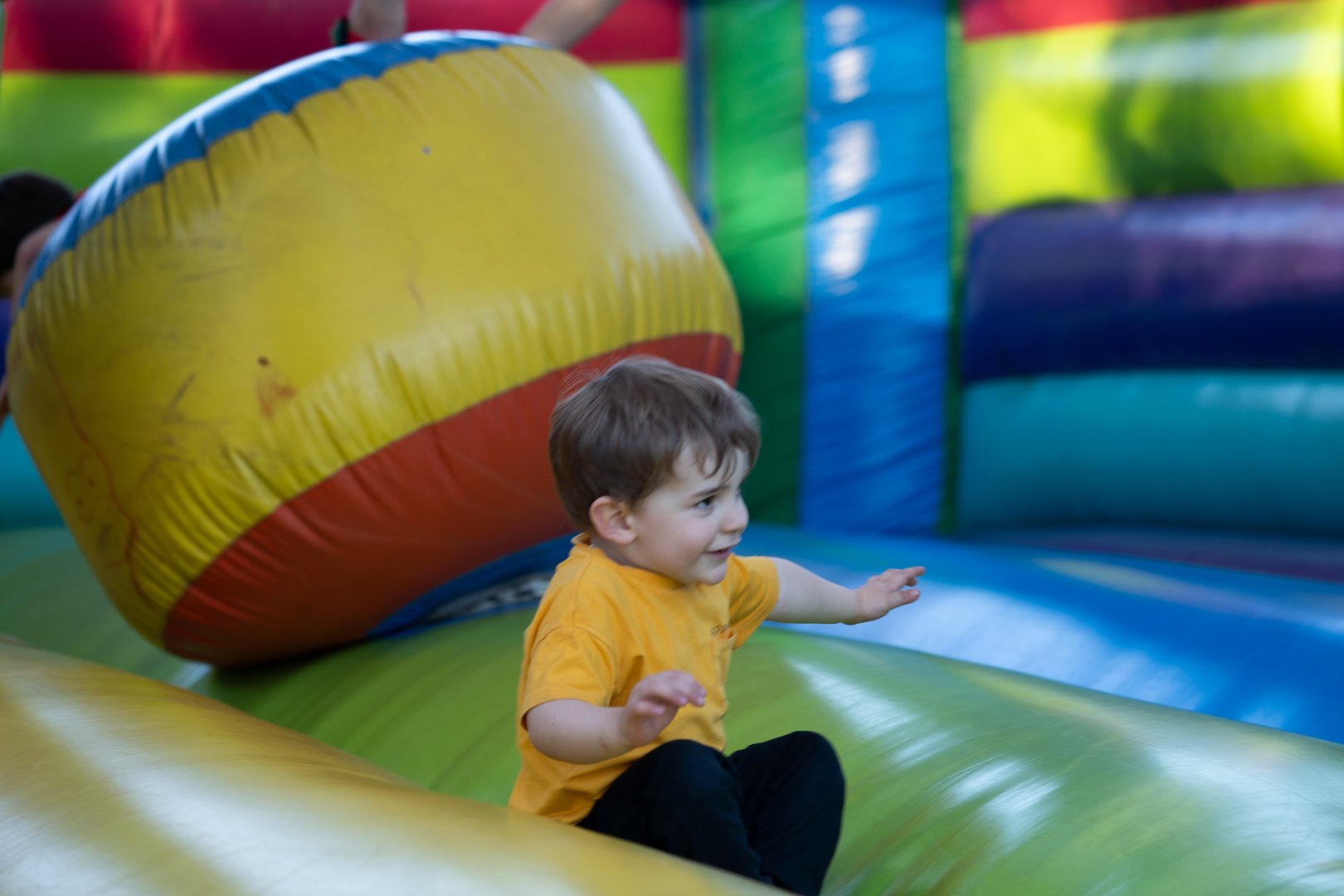 Young boy having fun jumping and playing on a colorful inflatable bouncy castle in a playground