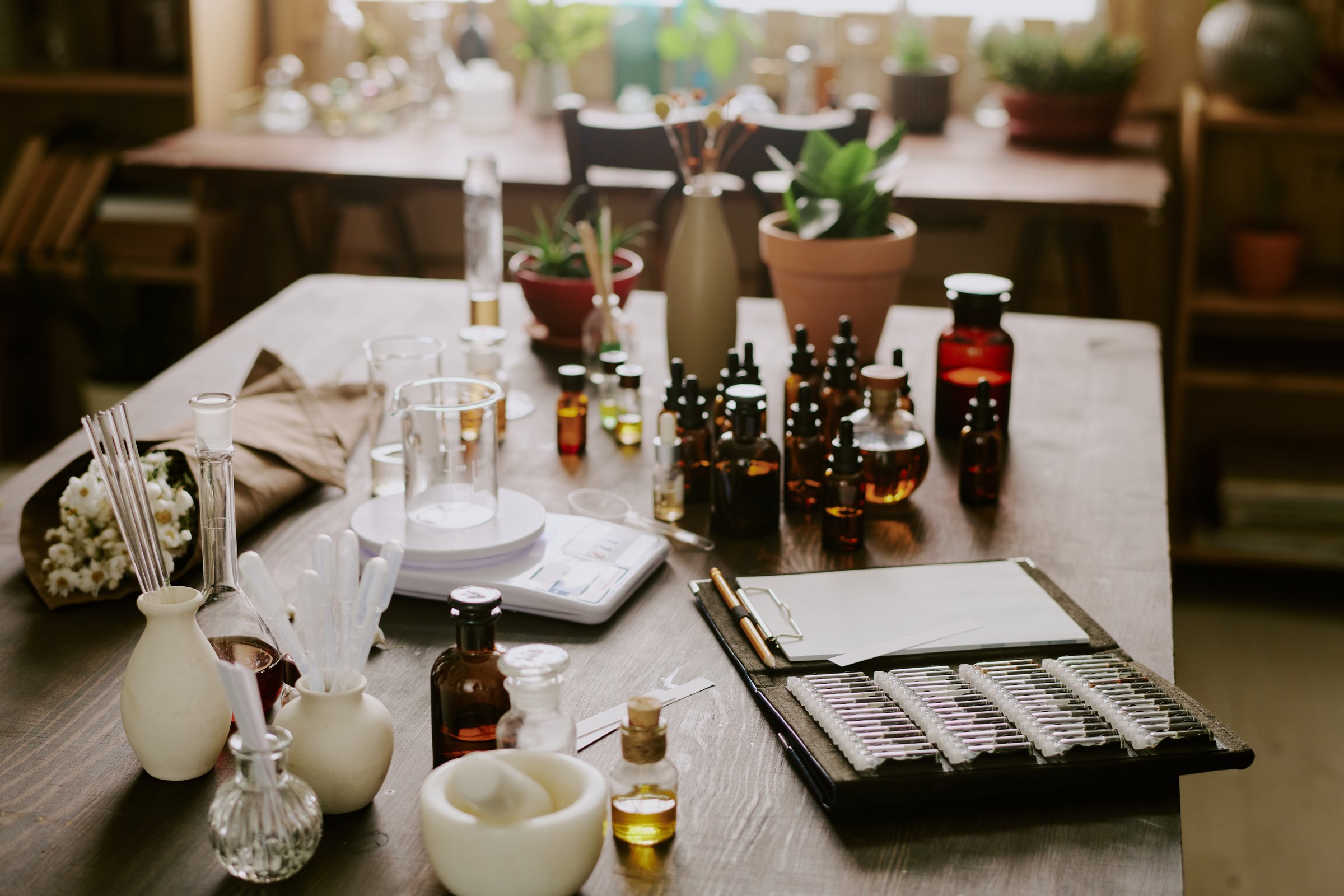 Small brown glass bottles full of essential oil and glass and plastic pipette on wooden table