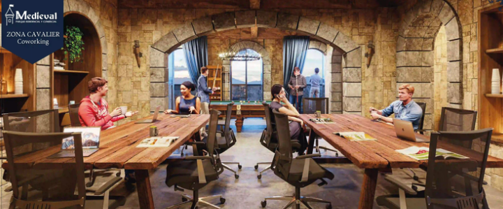Coworking space with medieval theme, featuring stone walls, wooden tables, and people engaged in conversation and work.