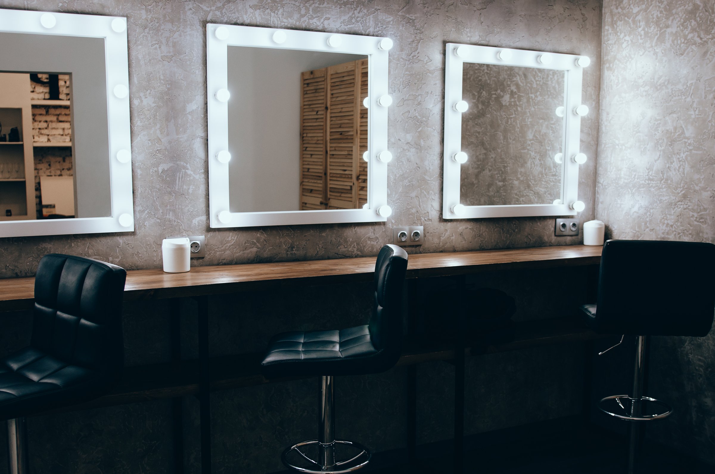 Interior of a beauty salon. Room with makeup mirror lights and black chair