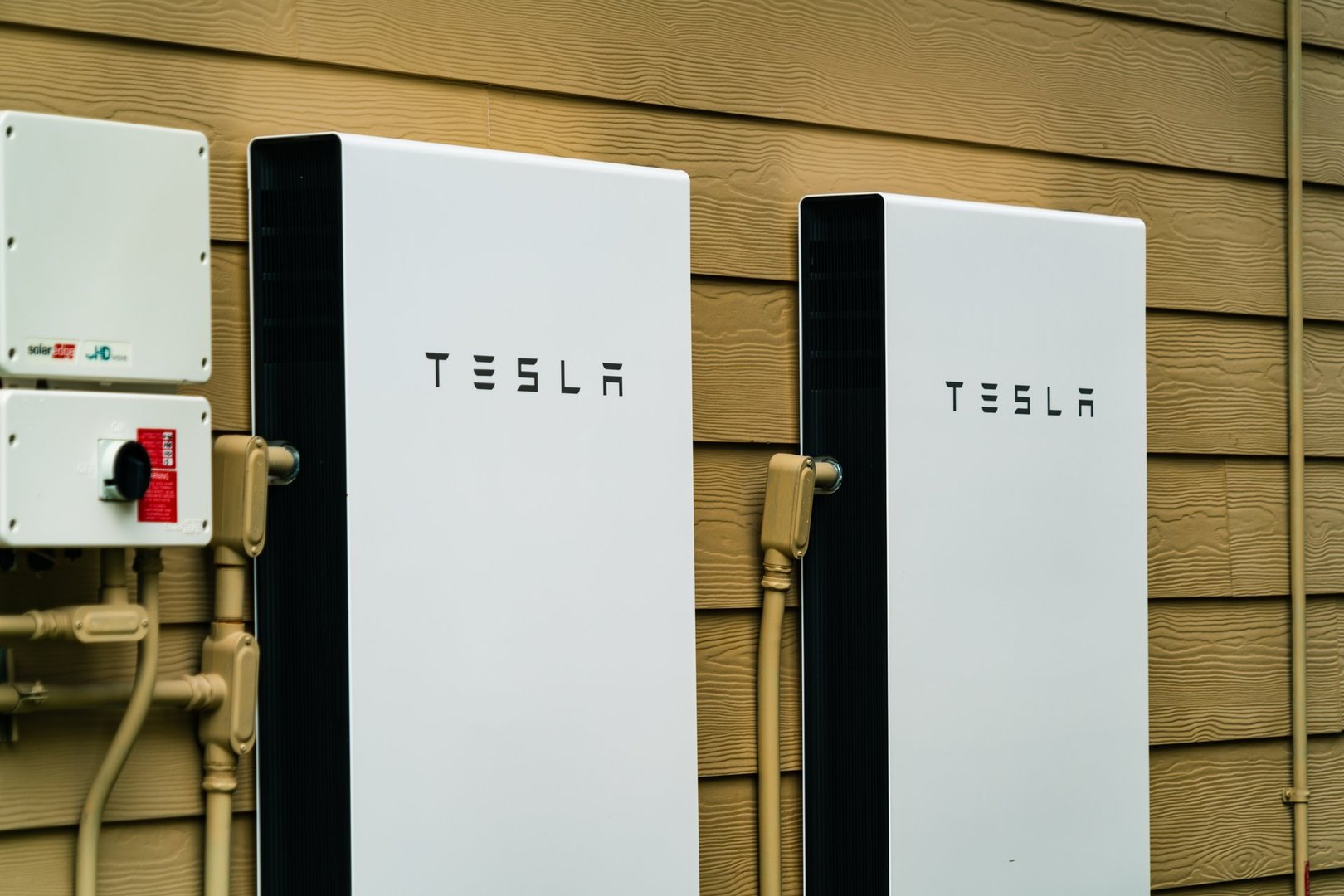 Tesla Powerwalls installed on the side of new urban suburban home for energy storage