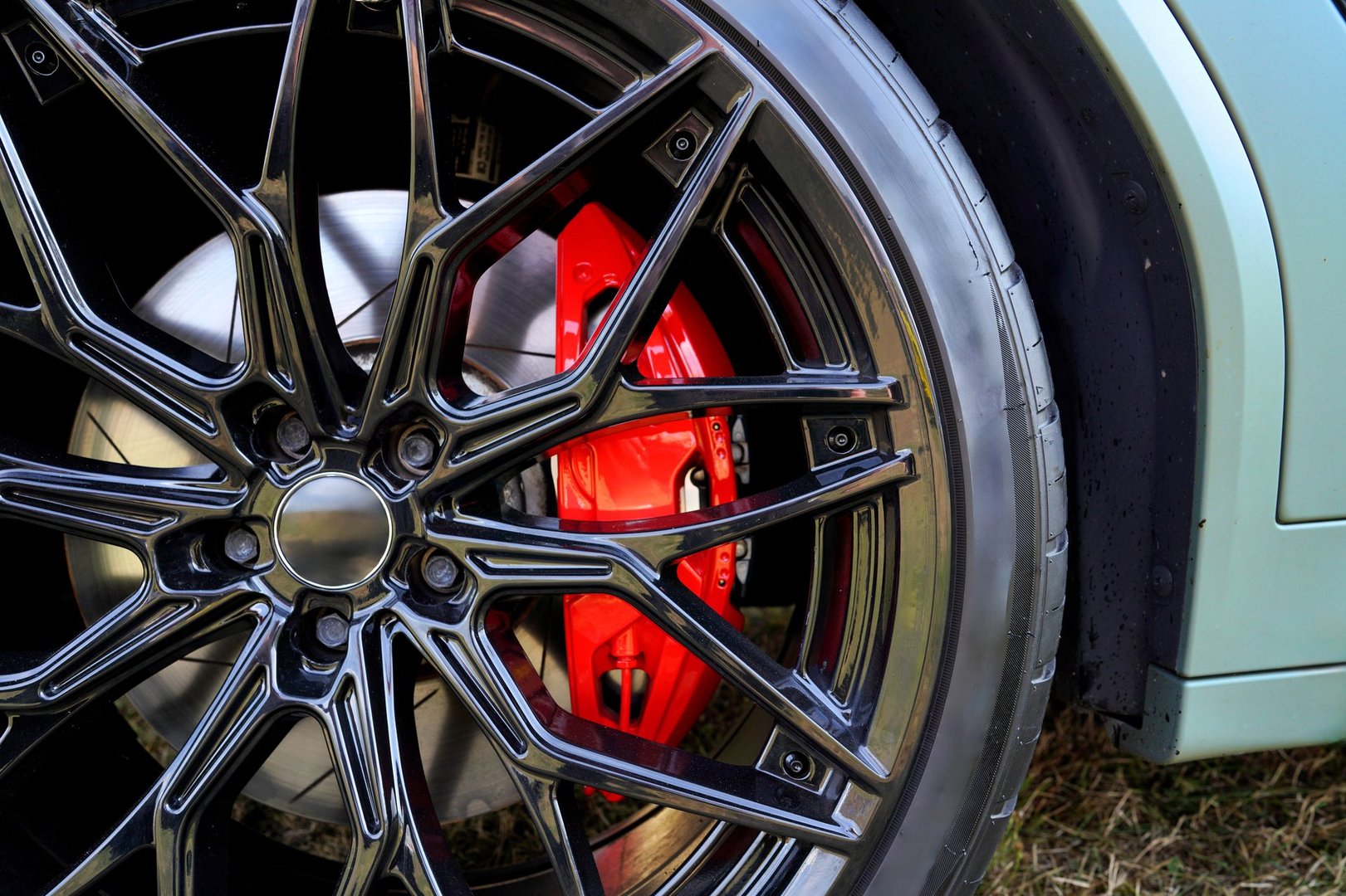 Racing brake disc and low profile tyres. Race car test driving. Lower-profile tires of drag and drift cars. High-performance sports cars. Alloy wheel with calipers and racing brakes of the sport car.