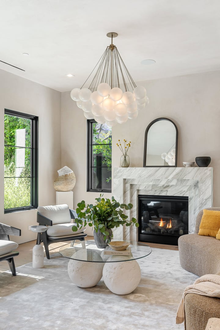 Sugarfree.space lifestyle - Modern living room with elegant chandelier, marble fireplace, and stylish decor