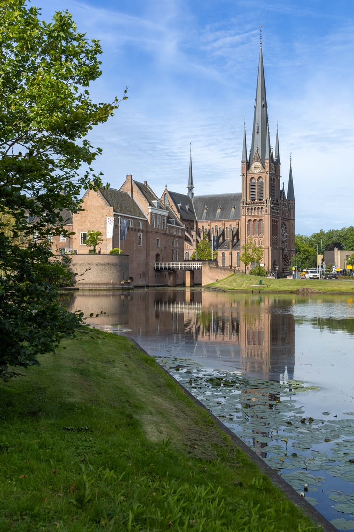 Historic Castle and Saint Bonaventure Church in Woerden Holland in a picture with pond in the foreground