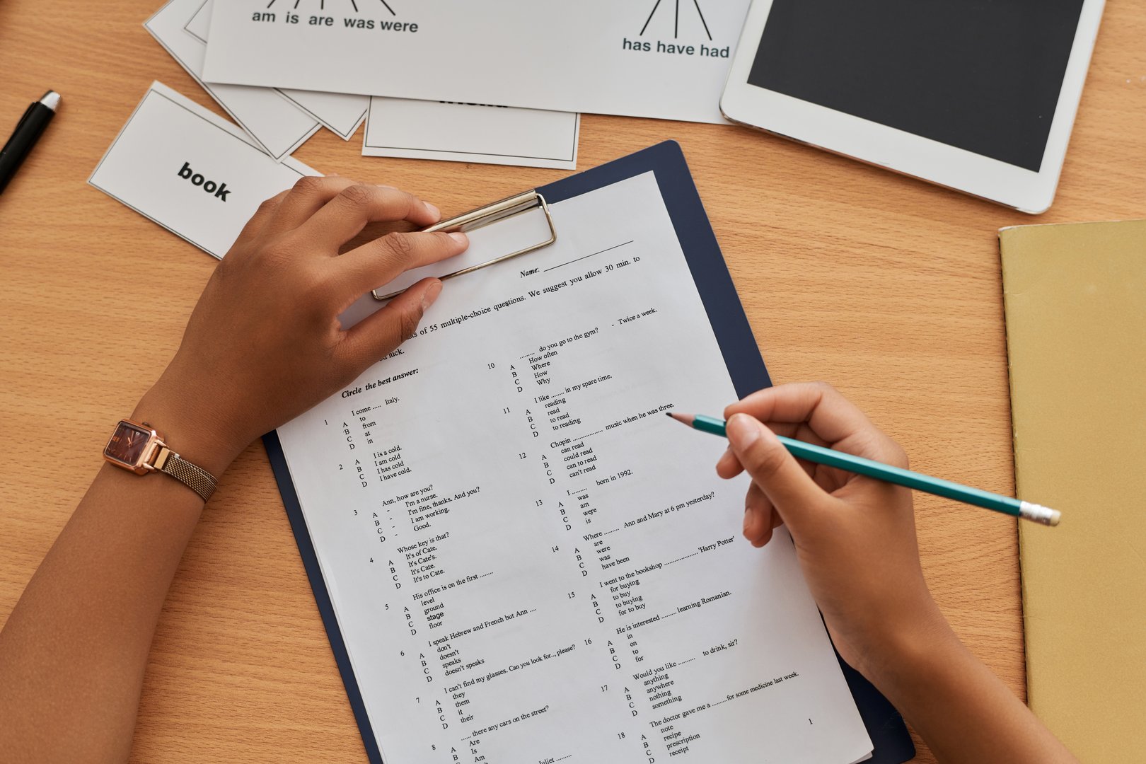 Top view of student writing foreign language test at table