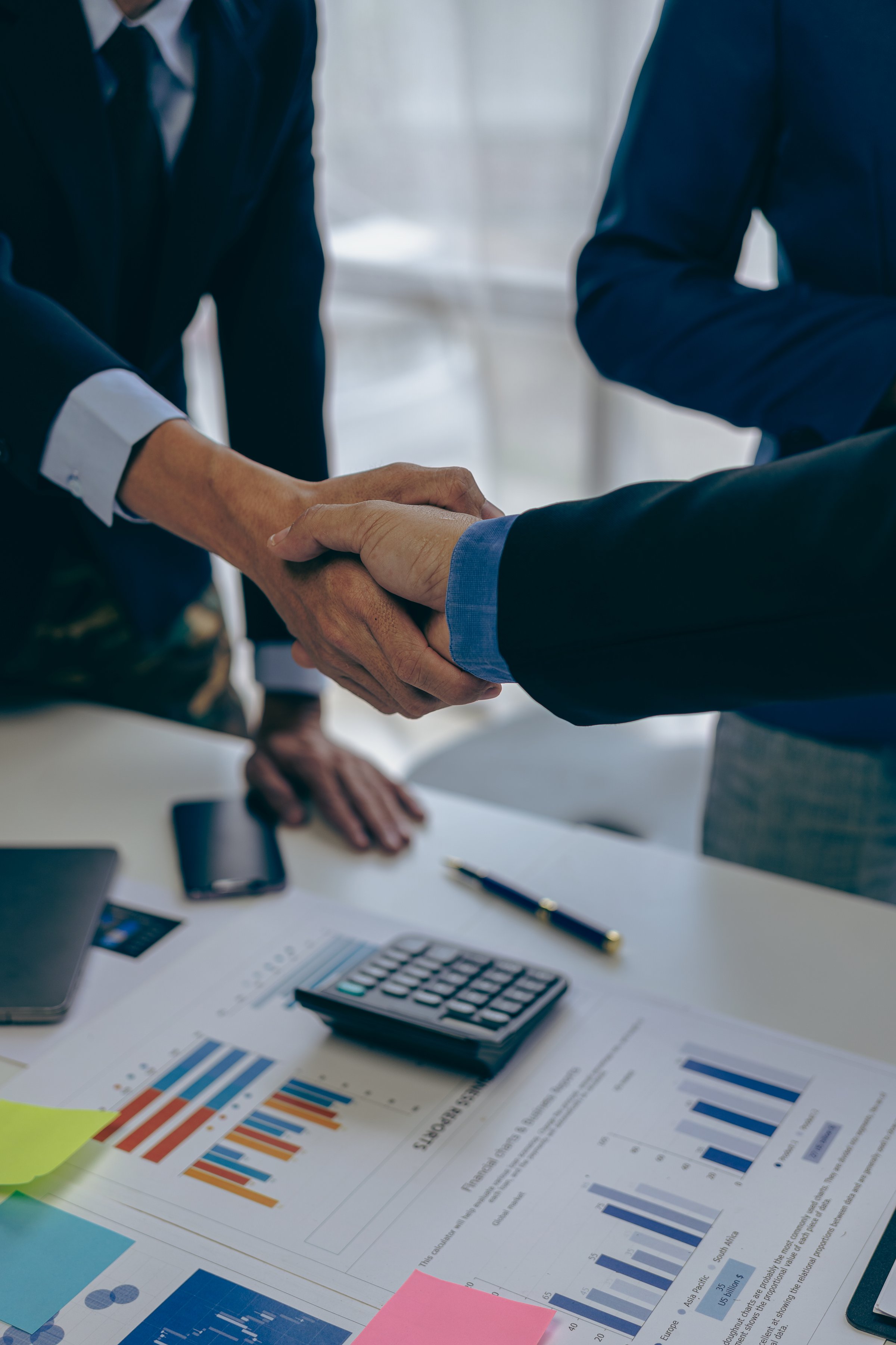 Business people shaking hands and meeting with the above documents to hire a partner or work together at the office in recruiting. Teamwork or research of a close-up marketing projec