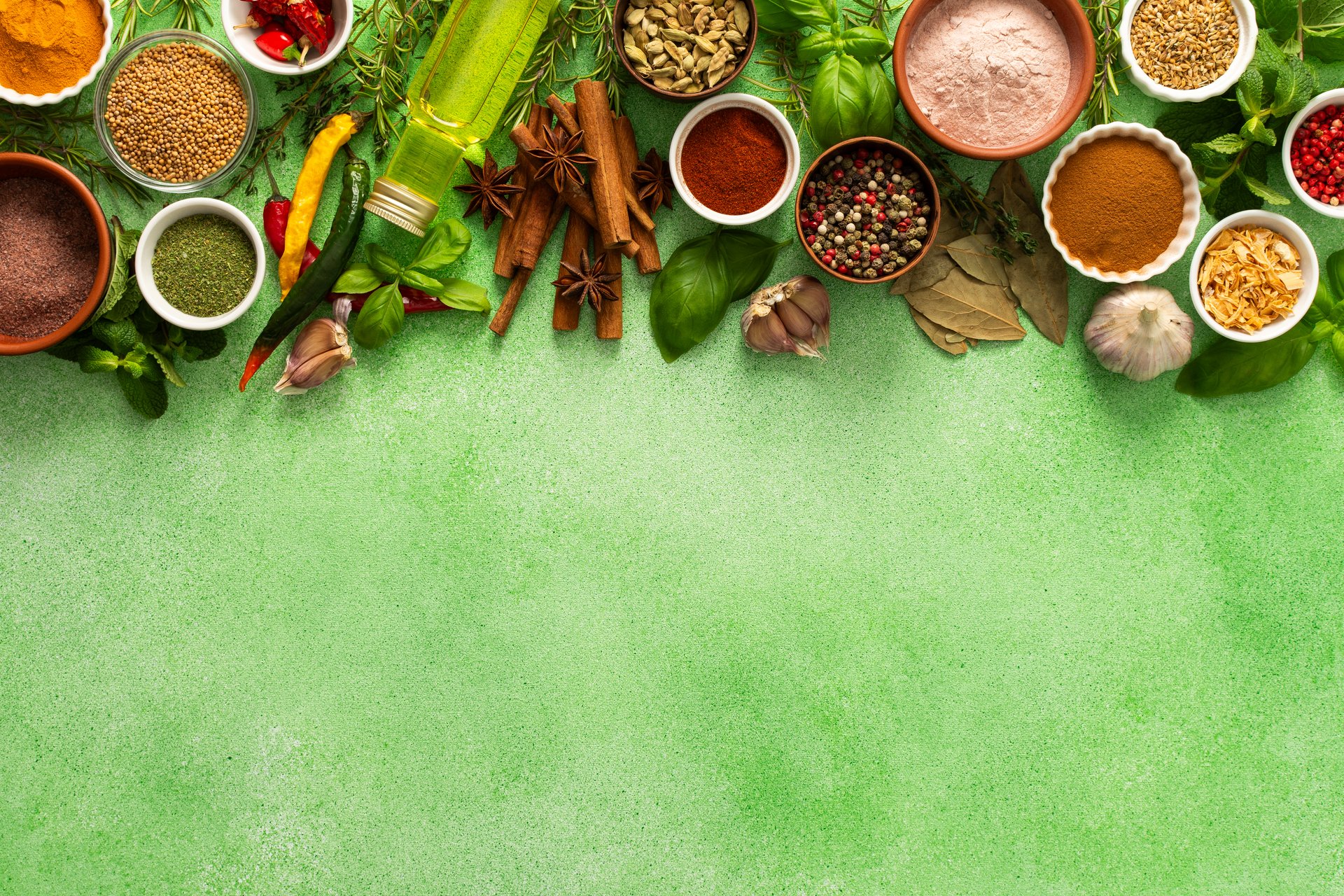 A vibrant assortment of fresh, multicolored spices and herbs on a delicate green background, perfect for cooking and culinary inspiration, top view, copy space