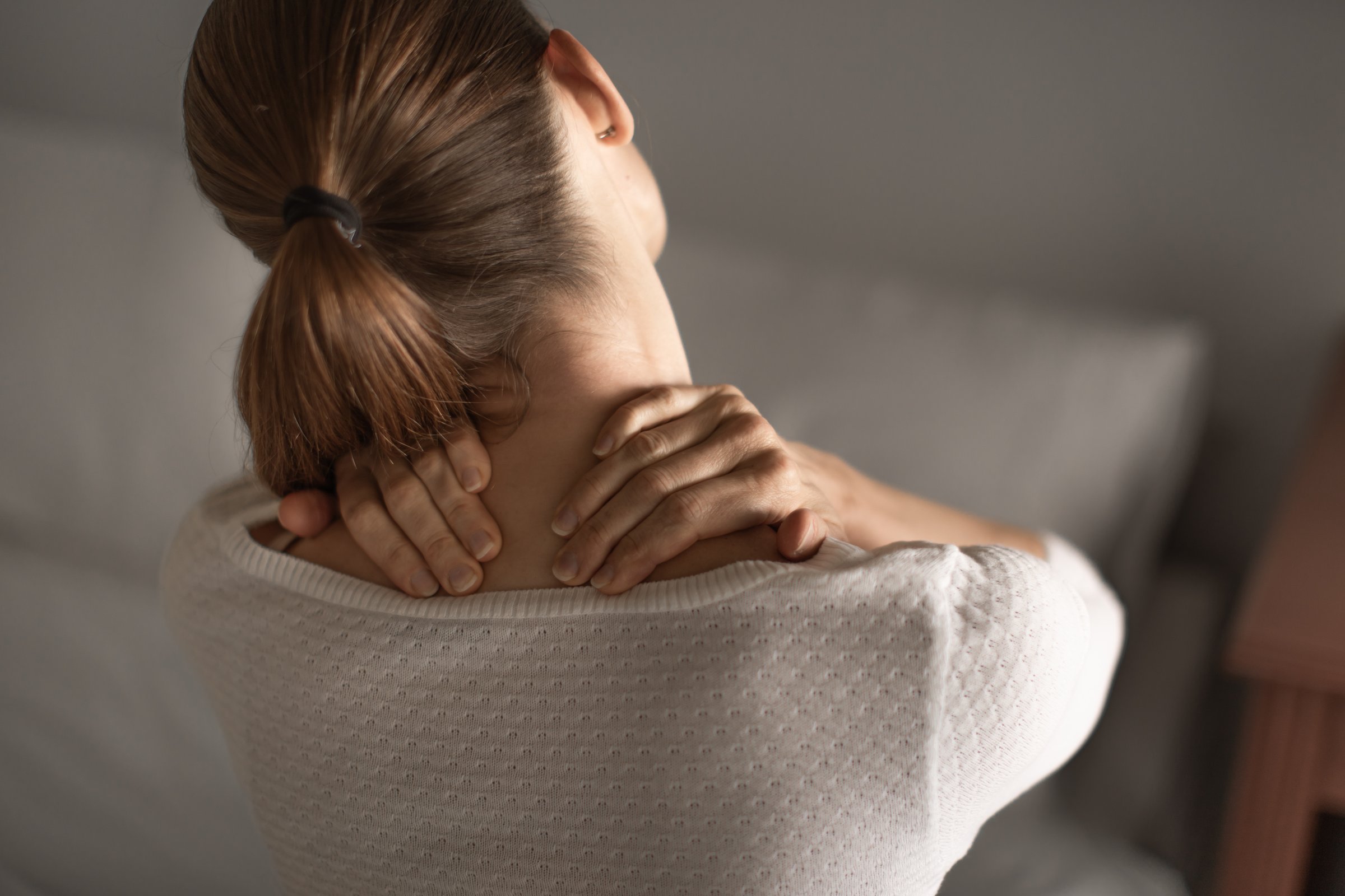 Woman with stiff neck pain.